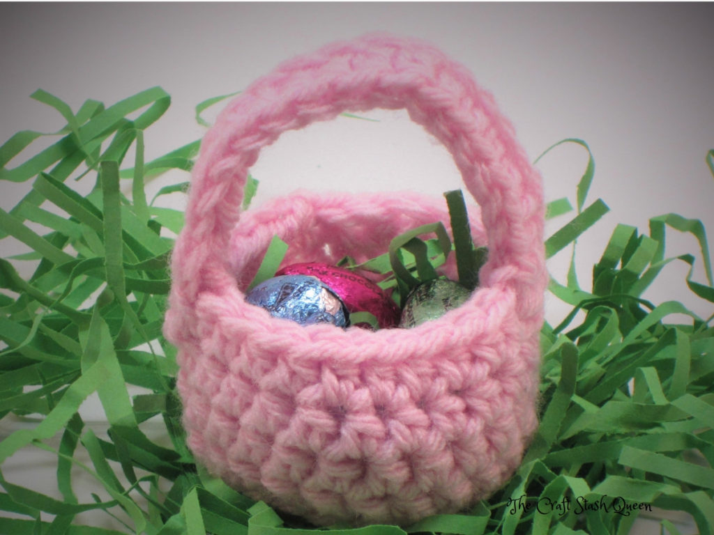 Pink mini crochet Easter basket containing candy.