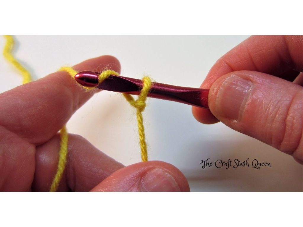 Demonstration of wrapping yarn over crochet hook.