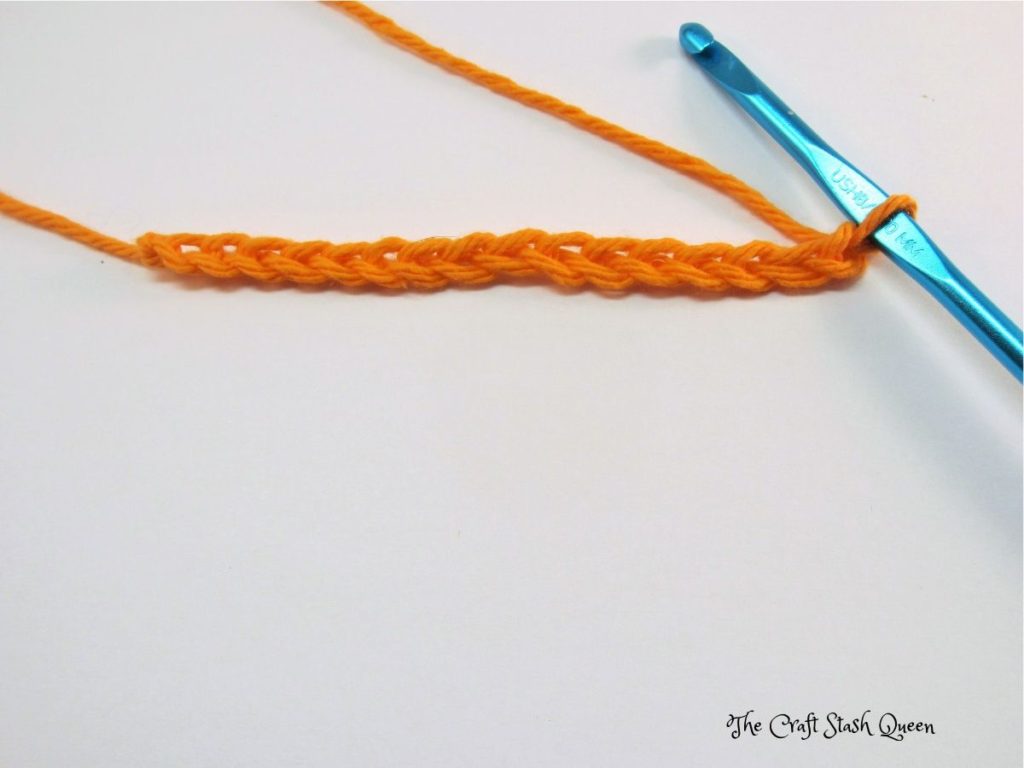 Orange yarn crocheted in a chain of 16.  Blue crochet hook.