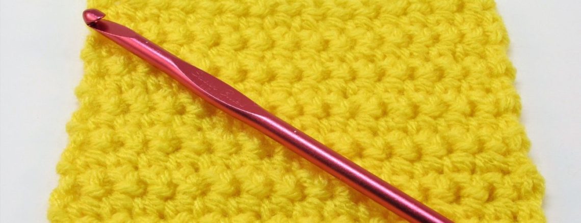 Single crochet swatch in yellow yarn. Red crochet hook.