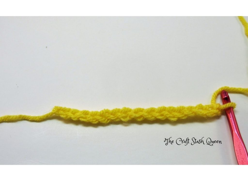 Yellow yarn crocheted in a chain of 16.  Red crochet hook.